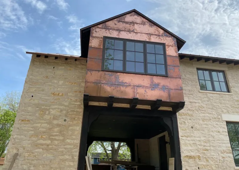Copper metal panel facade on a stone building for Skylight Installation in Cambria